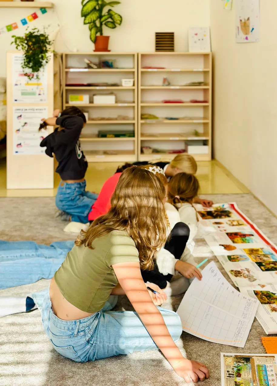 Žáci spolupracují na rozložených materiálech ve třídě